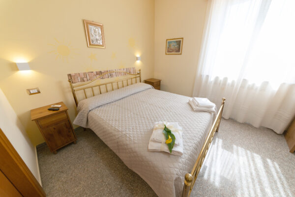 Letto matrimoniale con struttura dorata nella Camera Verde Ulivo a Montefalco