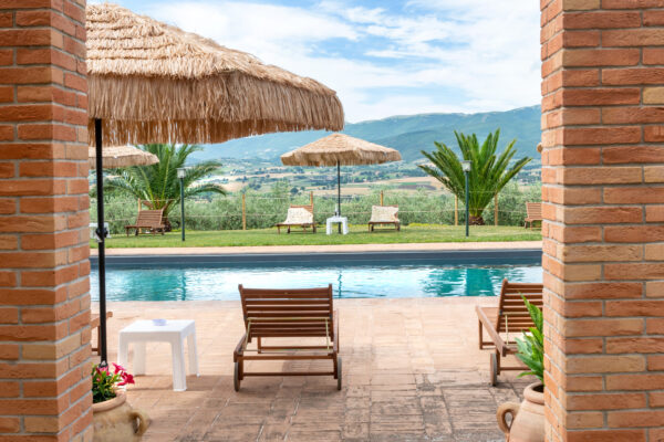 Vista della piscina e delle colline di Montefalco attraverso il porticato del Nido del Falco
