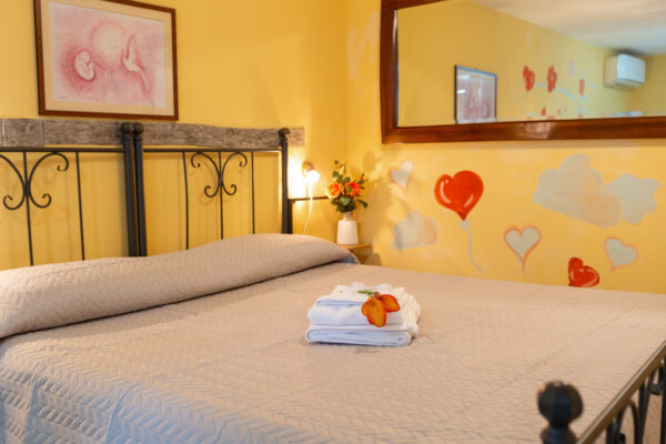 Letto matrimoniale con asciugamani e dettagli decorativi nella Camera Colle del Sole