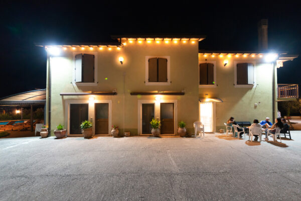 Facciata illuminata di notte e cortile del Nido del Falco a Montefalco