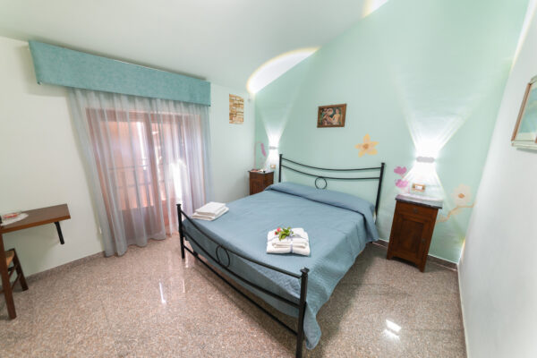Vista panoramica della Camera Vigna Antica con letto matrimoniale e pareti decorate