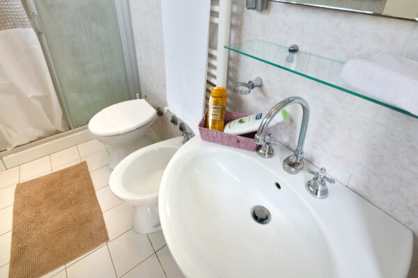 Lavabo con mensola in vetro nel bagno della Camera del Tramonto