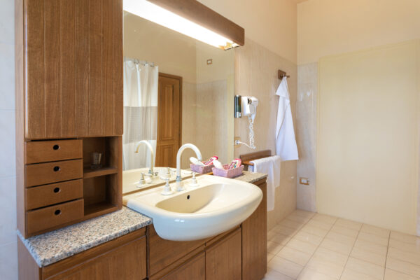 Lavabo e mobile in legno nel bagno della Camera del Falco a Montefalco