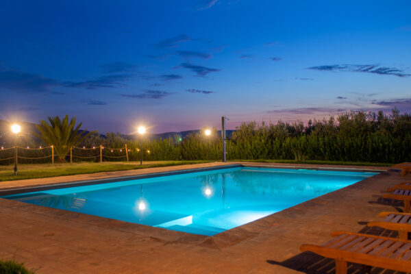 Piscina illuminata al crepuscolo al Nido del Falco a Montefalco