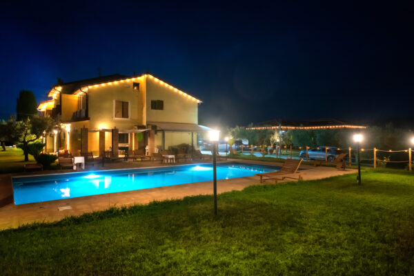 Vista notturna della piscina e dell’affittacamere Il Nido del Falco illuminati a Montefalco
