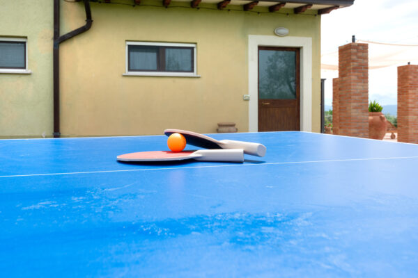 Tavolo da ping-pong con racchette e pallina negli esterni del Nido del Falco a Montefalco
