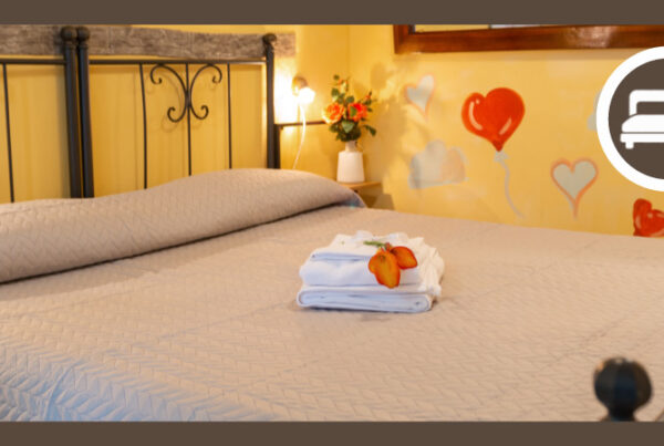 Letto matrimoniale in ferro battuto e pareti decorate della Camera Gialla al Nido del Falco